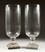 A PAIR OF CUT GLASS STORM LAMPS on square bases. 16ins high.