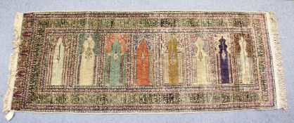 AN UNUSUAL PERSIAN PRAYER RUG, the central panel with eight arches and hanging lamps, within a