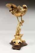 A GOOD GILT BRONZE CONCH SHELL SALT, held by a classical figure, on a marble base. 15ins high.
