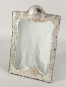 A GOOD SILVER UPRIGHT MIRROR with repousse decoration, flowers, scrolls and figures. London 18ins