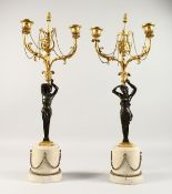 A SUPERB PAIR OF REGENCY BRONZE, ORMOLU AND MARBLE CANDELABRA, formed as bronze figures holding
