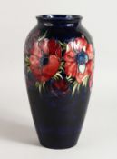 A WILLIAM MOORCROFT ANEMONE DESIGN VASE on a blue ground. Signed on base 12ins high.
