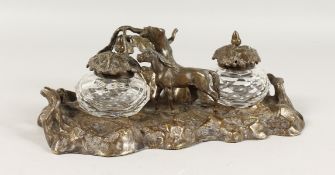 A VICTORIAN METAL INKSTAND OF RUSTIC DESIGN, with two glass inkwells and a horse. 9.5ins wide.