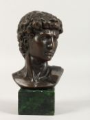 AFTER THE ANTIQUE A BRONZE ROMAN BUST on a marble base. 5ins high.