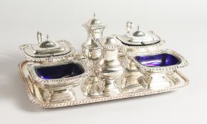 A SIX PIECE SHELL AND GADROONED CONDIMENT SET on a tray.