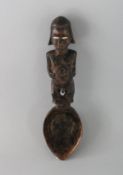 A CARVED WOOD TRIBAL SPOON. 9.5ins long.