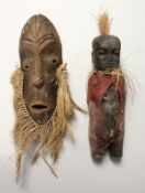A SMALL ETHNIC CARVED WOOD BABY FIGURE, 8ins long, and a MASK.