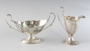 A HELMET SHAPED SILVER CREAM JUG AND SUGAR BASIN. London 1917.