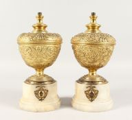 A GOOD PAIR OF GILT URNS on circular onyx bases. 9ins high.