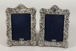 A PAIR OF SILVER UPRIGHT PHOTOGRAPH FRAMES with serpentine top and repousse decoration. 8ins x 5.