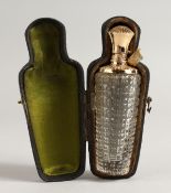 A CUT GLASS SCENT BOTTLE with gold top, in a fitted case. 3.5ins long.