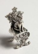 A MINIATURE SILVER CAT ON A CHAIR.