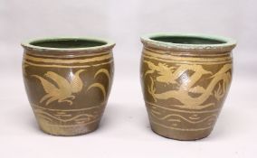 A NEAR PAIR OF CHINESE POTTERY JARDINIERES, dragon and phoenix design. 1ft 8ins diameter.