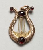 A GOLD AND RUBY LYRE-SHAPED PENDANT.
