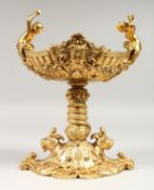 A GOOD GILT BRONZE PEDESTAL SALT with cupids. 8.5ins high.