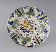 AN EARLY SPANISH FAIENCE DISH in mainly blue and yellow. 10.5ins diameter.