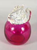 A GOOD RUBY GLASS RAM CLARET JUG with plate head. 7.5ins high.