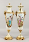 A PAIR OF SEVRES STYLE PORCELAIN URNS AND COVERS painted with classical figures, with ormolu mounts.