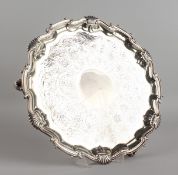 A GEORGE II SILVER PIECRUST SALVER, 13ins diameter, with engraved body, on three knurled feet.