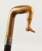A 19TH CENTURY WALKING STICK, the handle as a carved wood ISLE OF MAN TYPE LEG with plain silver
