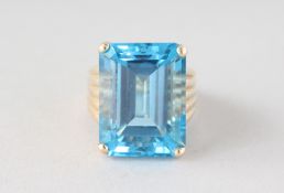 A LARGE GOLD BLUE TOPAZ RING.