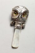 A SILVER AND MOTHER-OF-PEARL OWL RATTLE.