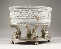 A GOOD FRENCH SILVERED METAL OVAL STAND with four dolphin supports, oval base holding a cut glass