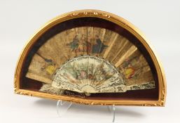 A GOOD 18TH CENTURY FRENCH IVORY AND PAPER FAN in a glass case, printed with figures. 20ins open.