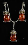 A SILVER AND AMBER OWL NECKLACE AND EARRINGS.