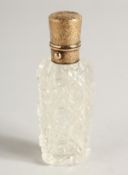 A CUT GLASS SCENT BOTTLE with gold top, in a fitted case. 3.5ins long.