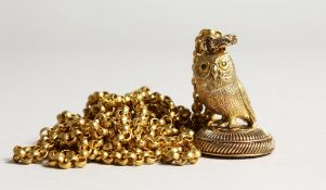 A GOLD PLATED OWL SEAL ON A CHAIN.