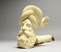 A LARGE CARVED MEERSCHAUM PIPE, head of a man, in a leather case. 16ins long.
