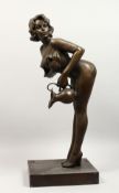A LARGE BRONZE FIGURE OF A STANDING FEMALE SEMI-NUDE, leaning forward, holding a jug in her left