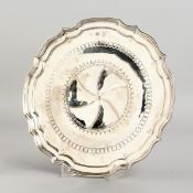 A CONTINENTAL SILVER PIECRUST SALVER, 9.5ins diameter, with star centre, on four knurled feet.