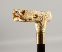 A CARVED BONE HANDLED WALKING CANE, 