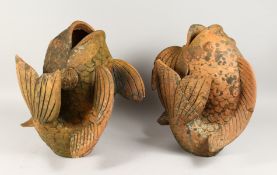 A PAIR OF TERRACOTTA CARP SHAPED VASES. 1ft 6ins high.