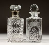 TWO CUT GLASS SQUARE DECANTERS AND STOPPERS, one with silver base.