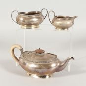AN OVAL SILVER TEAPOT, SUGAR BASIN AND MILK JUG. Birmingham 1932 and London 1928. Gross Weight: