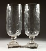A PAIR OF CUT GLASS STORM LAMPS on square bases. 16ins high.