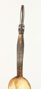 A HORN SPOON, the handle carved with a figure. 12ins long.