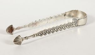 A PAIR OF GEORGIAN PIERCED SILVER SUGAR TONGS. Maker C. H.