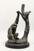 A CAST BRONZE GROUP OF A CHIMP SEATED BY A TREE, on a marble base. 15ins high.