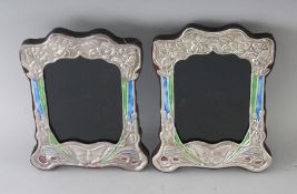 A PAIR OF NOUVEAU SILVER AND ENAMEL BUTTERFLY PHOTOGRAPH FRAMES. 8ins x 6.5ins.