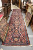 A Persian runner, or hall carpet, dark blue ground with stylized floral decoration.