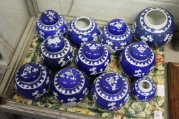 A quantity of Chinese blue and white prunus pattern ginger jars and covers.