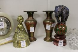 A brass figural bell, a model of an elephant on a ball and a pair of eastern brass vases.