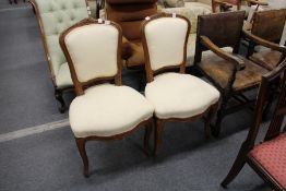 A pair of French style beech framed and upholstered dining chairs.