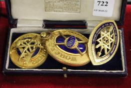 Three decorative gilt and enamel badges.