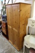 A modern pine two door linen cupboard.