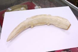 A carved bone model of an alligator.